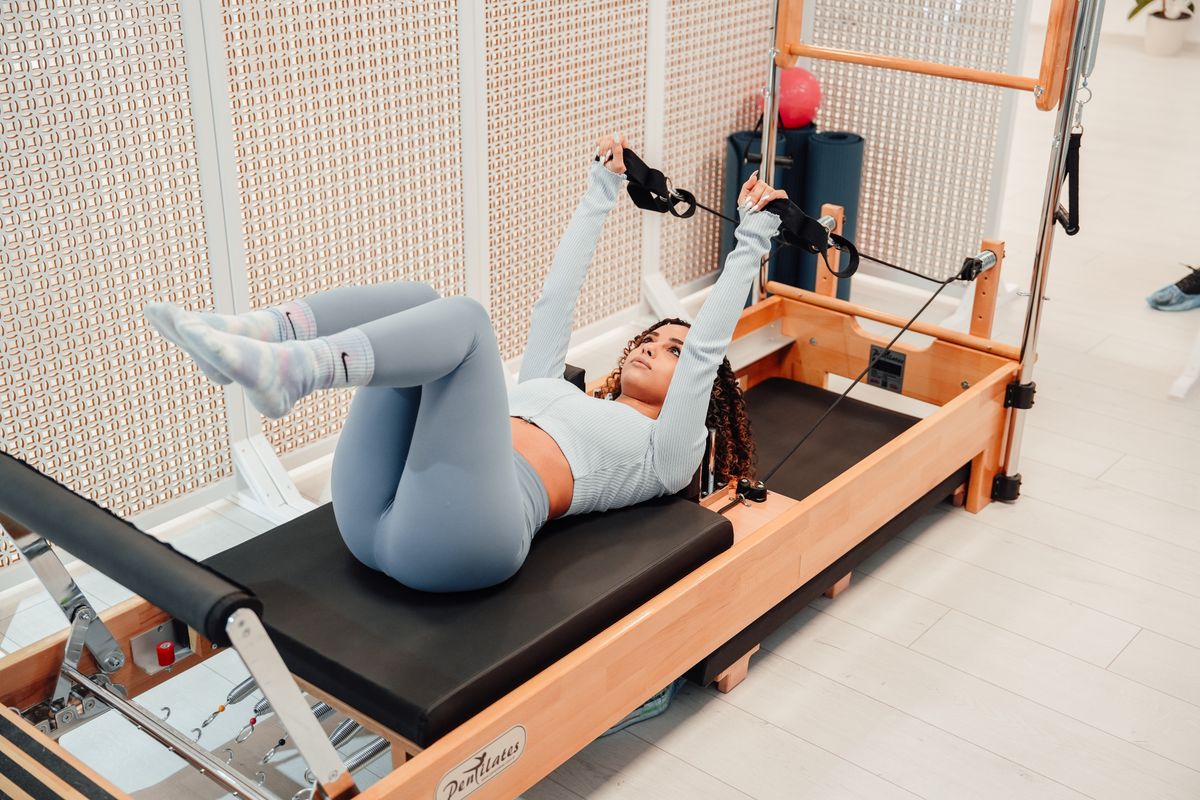 Aluna praticando Pilates no reformer